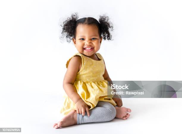 Happy Little Girl In A Yellow Dress Sitting Stock Photo - Download Image Now - Child, Baby - Human Age, White Background
