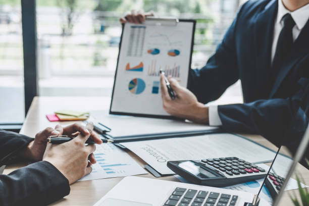 istock Two executive discussing company growth project success financial statistics, Partner meeting professional investor working start up project for both company with document, laptop and digital tablet 1076517752