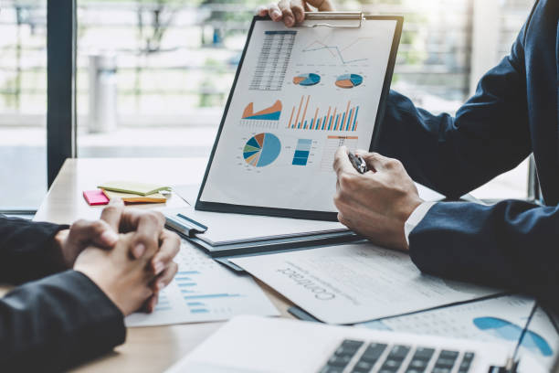 istock Two executive discussing company growth project success financial statistics, Partner meeting professional investor working start up project for both company with document, laptop and digital tablet 1076517762