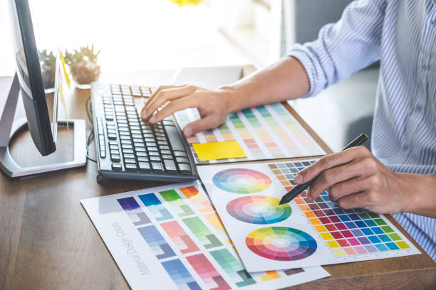 istock Image of male creative graphic designer working on color selection and drawing on graphics tablet at workplace with work tools and accessories in workspace 1076517804