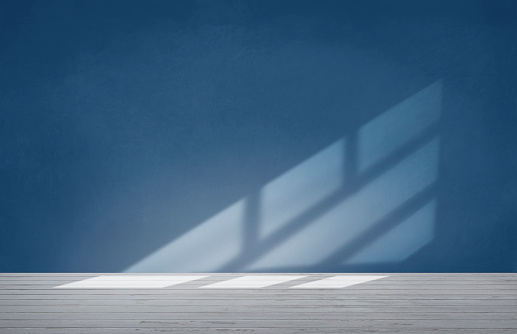 Blue wall in an empty room with concrete floor