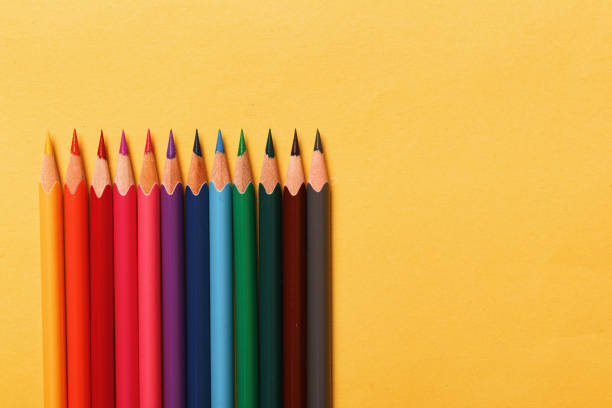 istock Multicolored pencils lie on a yellow background 1076523140