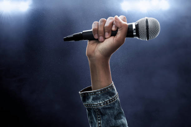 Hand holding microphone stock photo