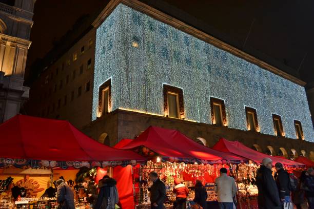 mercato festivo del duomo di milano con gazebo rossi, il negozio rinascente e persone che camminano. - holidays and celebrations church wall italy foto e immagini stock