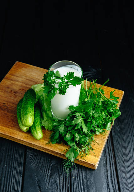 istock Fresh plain homemade yougurt with cucumber herbs over dark background, probiotic cold fermented dairy drink. 1076529182