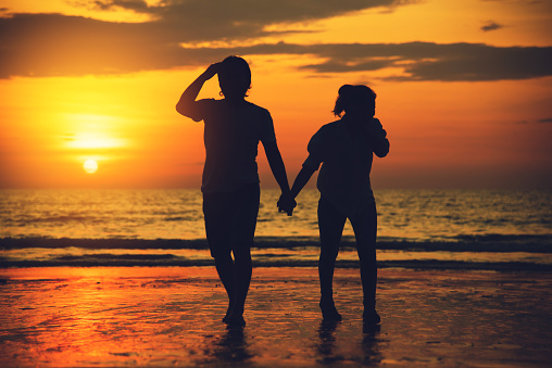 Asian lovers happy and having fun holding hands. Travel beach summer vacation.