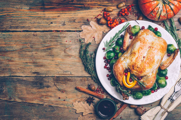 istock Thanksgiving roasted chicken with Brussels sprouts and spices on a rustic wooden table. Thanksgiving dinner or fall dinner concept background with autumn leaves. Thanksgiving table setting background. 1076532198