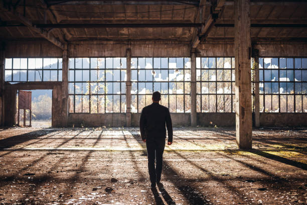 istock Handsome Man walk thru the Empty Factory 1076532812