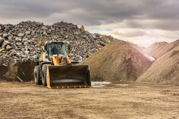 экскаватор работает в карьере со скалой - earth mover digging land bulldozer стоковые фото и изображения