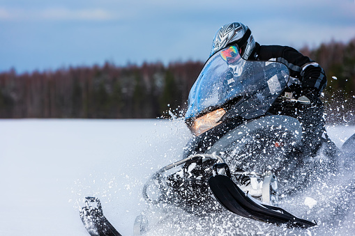 En jinete de motos de nieve polvo profunda Ventisquero conducir rápido. photo