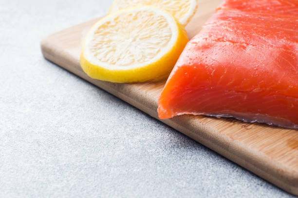 istock Fresh salmon fillet with lemon on a cutting Board. Copy space 1076536476
