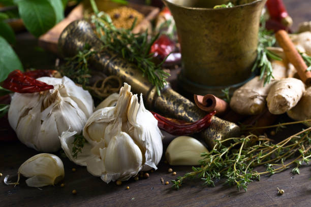 different herbs and spices with ginger on a wooden table. - mortar and pestle spice seasoning coriander seed imagens e fotografias de stock