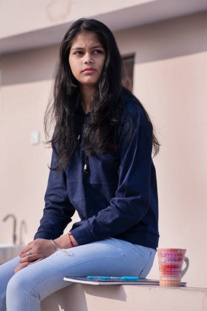 istock sad girl siting alone with cup of coffee mug 1076564402