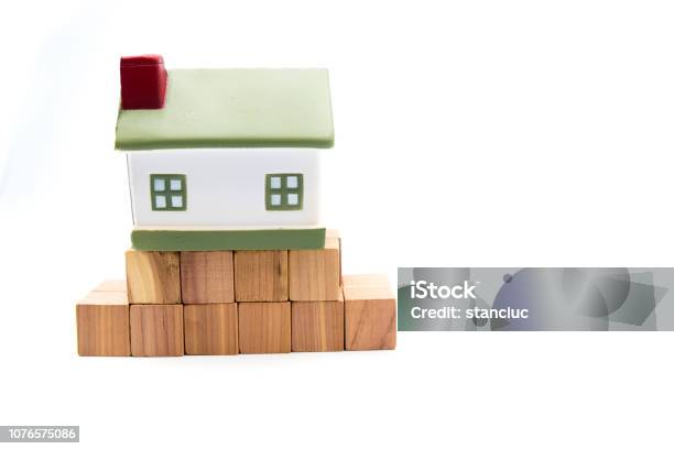 Miniature Model House On Fundation Of Wooden Cubes Isolated On White Stock Photo - Download Image Now