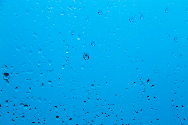 istock Natural water drop background on glass. Blurred city 1076578536