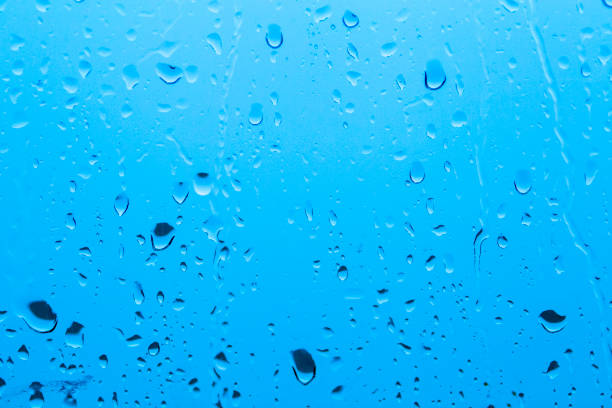 istock Natural water drop background on glass. Blurred city 1076578798
