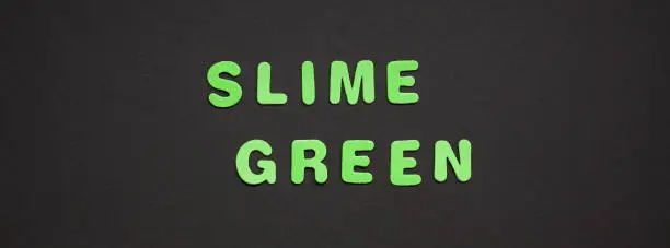 Photo of Slime green writing on black paper background