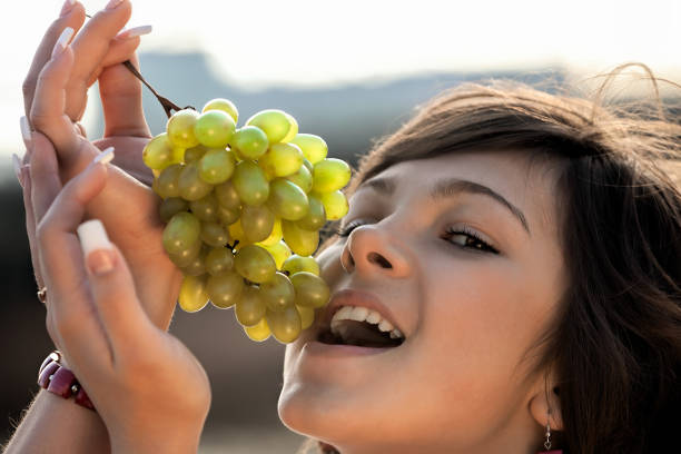 young woman at park - She is eating grape