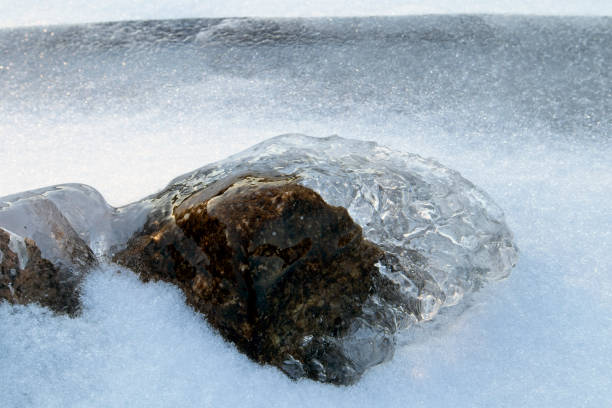 ice covered stone on lake shore, Finland