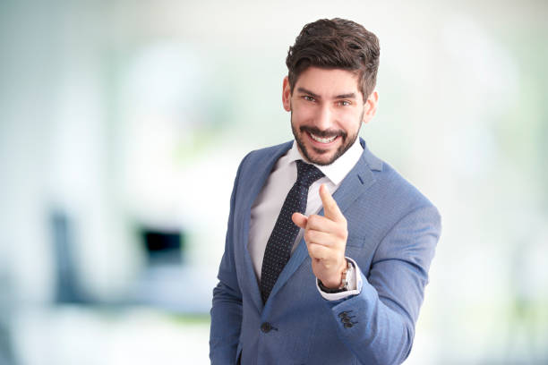 istock Cheerful young businessman points his finger at you 1076591508