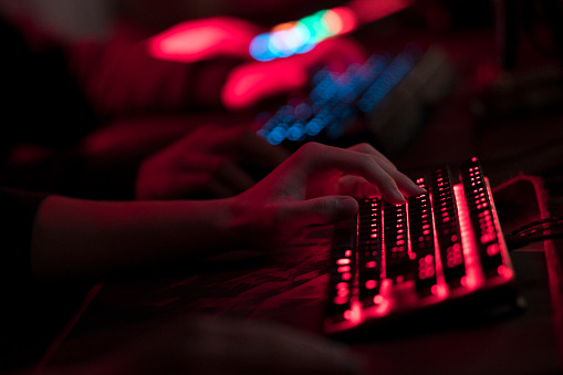 Hands on an illuminated gamer keyboard
