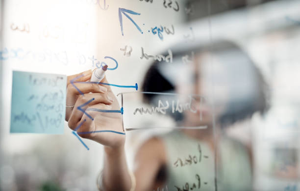 The formula for success Cropped shot of an unrecognizable young businesswoman working on a glass wipe board in her office transparent wipe board stock pictures, royalty-free photos & images