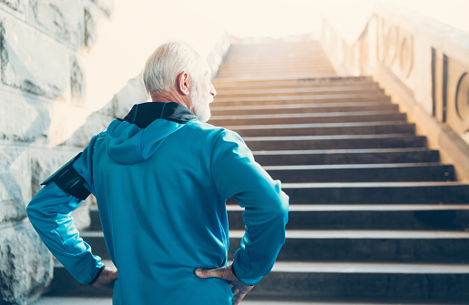 Senior Man preparing to workout  in urban environment on the stairs