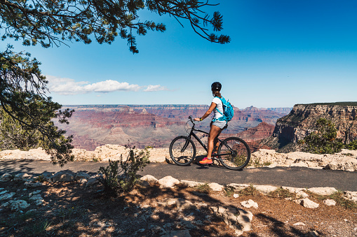 Young woman cycling through Grand Canyon park