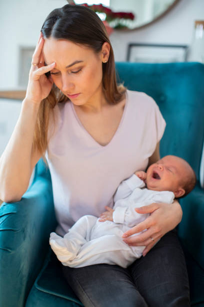istock Stressed Mother Holding Crying Baby Suffering From Post Natal Depression At Home 1076596852
