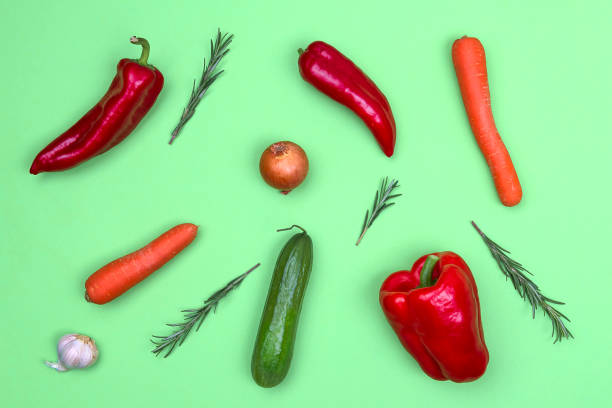 istock Fresh vegetables on light green background. Pepper, carrot, onion, cucumber, basil. 1076600408