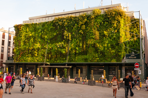Avignon, France - July 22, 2011: Green plants living facade of Less Halles with walking around people in Avignon, France during the Art Festival Off.