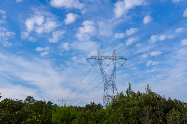 istock Pylons of High-Voltage Power Lines and a Blue Sky with Clouds 1076609116