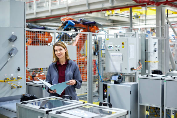 istock Female engineer holding file in car plant 1076609466