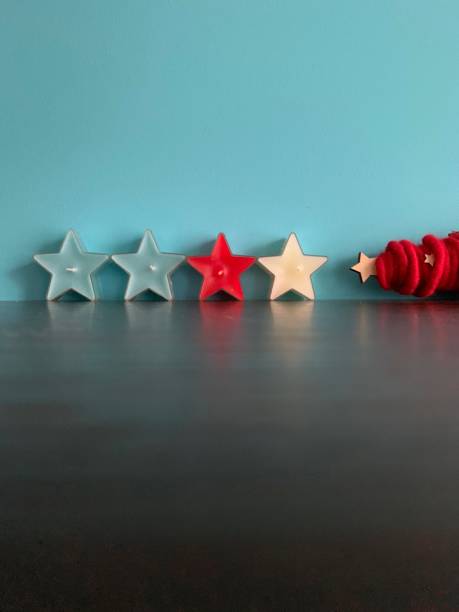 istock Star shaped candles and a red christmas tree on blue background 1076610612
