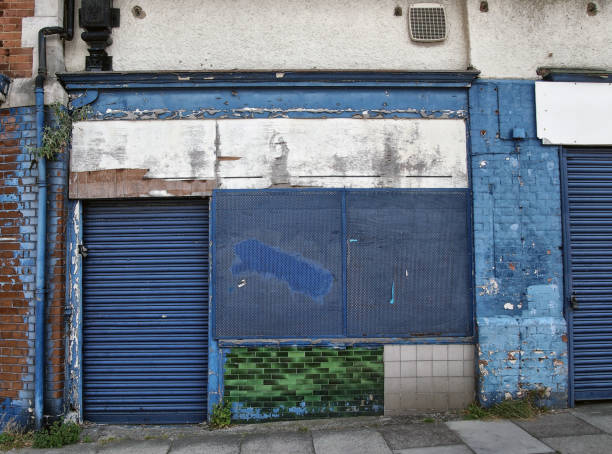 istock abandoned derelict shop with storefront boarded up with peeling blue paint decaying facade and exposed tiles and brickwork 1076612158