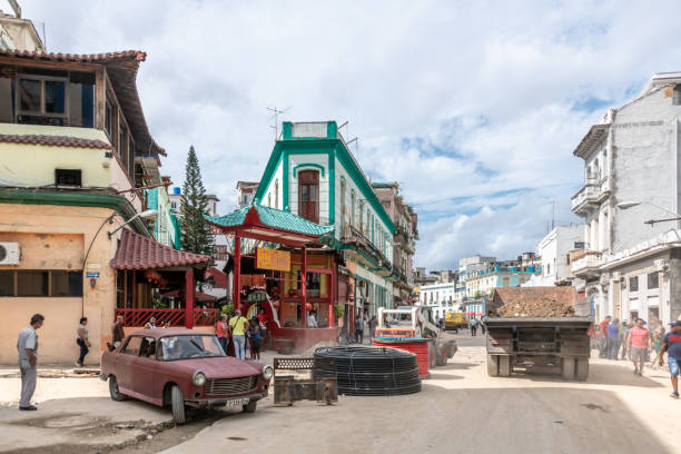 Havana, Cuba. 22nd November 2018. A car exits the area as building work is going on in Chinatown in Havana, Cuba. A truck with rubble goes by.