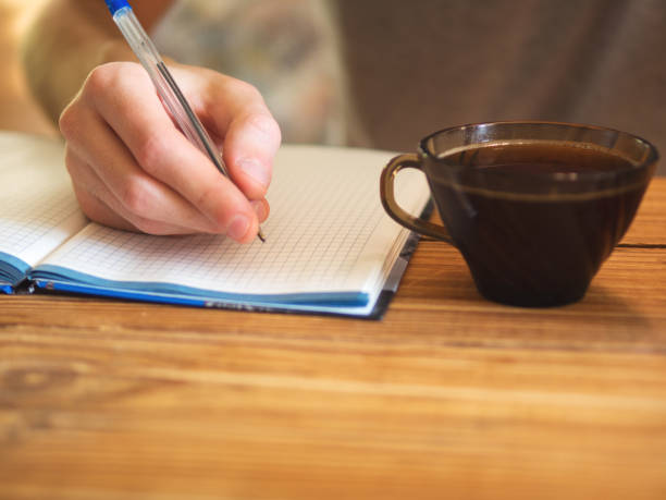 istock A man with a Cup of coffee and a notebook at the table 1076613230