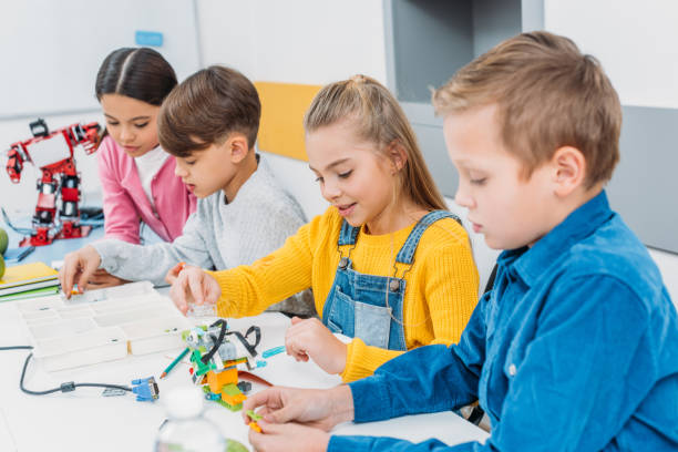 istock concentrated children sitting at desk and making robots in stem education class 1076614282
