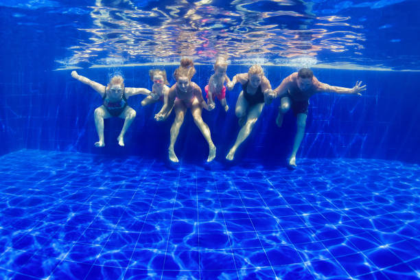 istock Happy family dive in swimming pool 1076620716