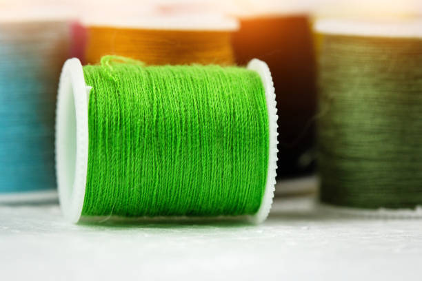 The green roll of thread on background,needlework,craft,sewing and tailoring concept,blurry light around