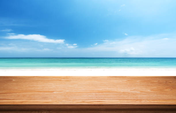 istock Empty Wooden Table With Sunny Beach Background 1076628998