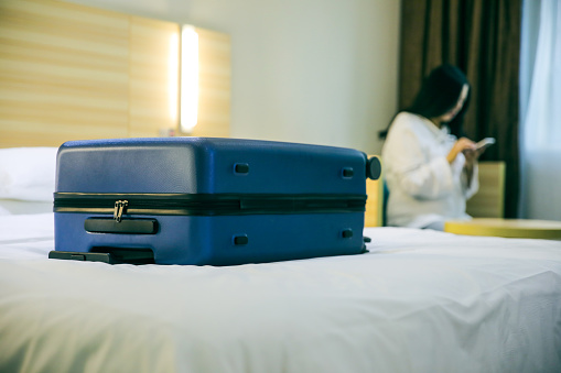 Luggage in hotel with woman using phone background