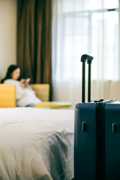 istock Luggage in hotel with woman using phone background 1076634482