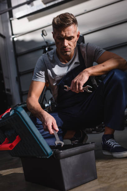 istock mechanic sitting by toolbox on floor in garage 1076641968