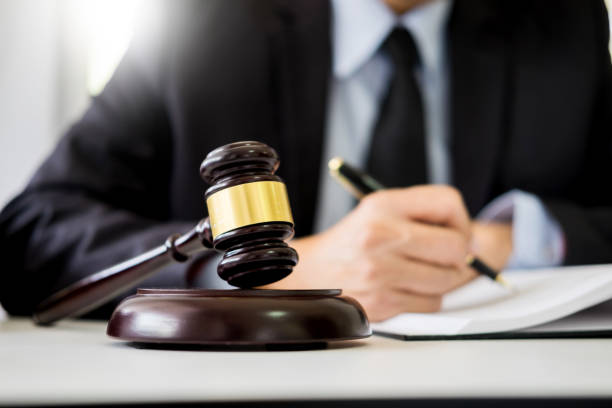 istock Close-Up Of Gavel On Table With Judge In Background 1076642486