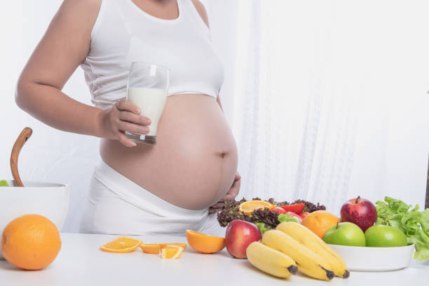 istock Midsection Of Woman Holding Milk While Standing By Table 1076647434