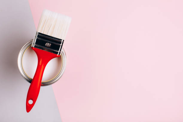 istock Brush with red handle on open can with pink paint on pastel background. 1076655944