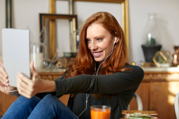 태블릿 pc에 selfie를 복용 하는 헤드폰을 가진 여자 - irish culture audio 뉴스 사진 이미지