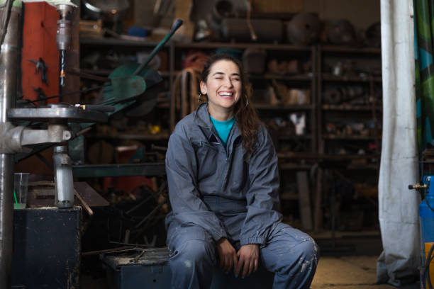 작업장에 앉아 있는 행복한 중년 여성 - mechanic 뉴스 사진 이미지