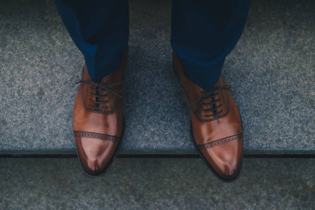 istock Low Section Of Man Wearing Shoes While Standing On Steps 1076661652